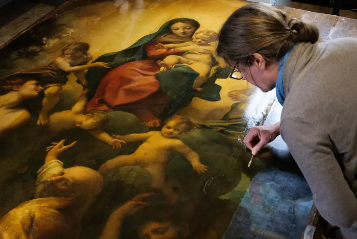 eine Restauratorin entfernt den vergilbten Firnis vom Altarbild