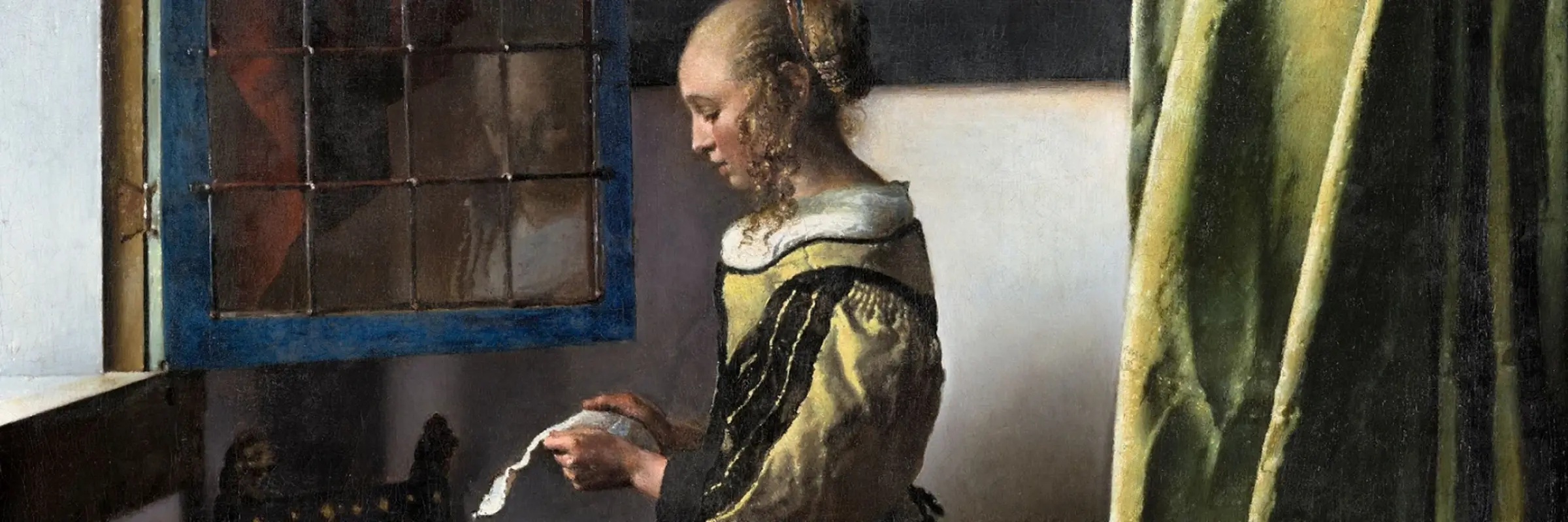 Girl standing at the window reading a letter