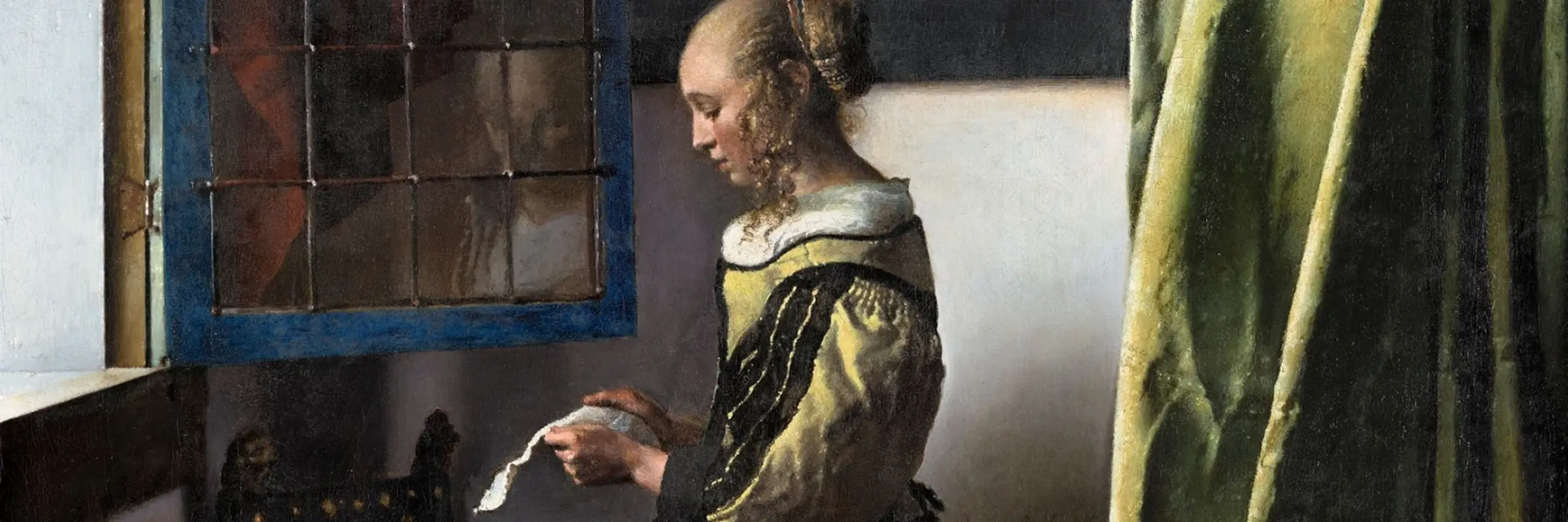 Girl standing at the window reading a letter