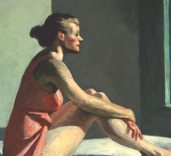 Eine auf einem Bett sitzende, leichtbekleidete Frau schaut aus dem Fenster vor ihr