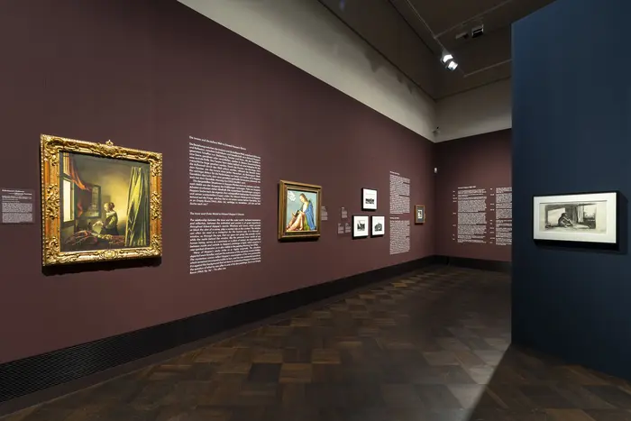 Eine Austellungansicht mit Texten und Gemälden