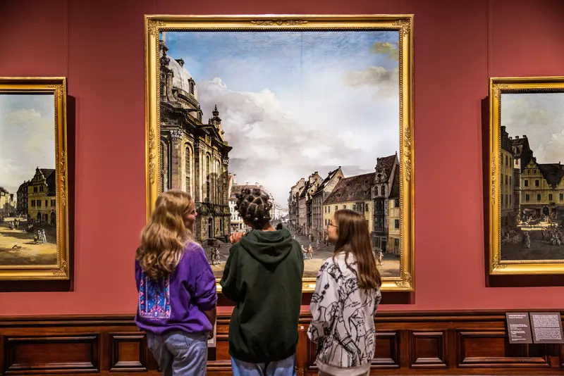 Besucher sitzen vor Gemälden und zeichnen
