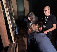 Experten stehen vor dem Gemälde und beraten