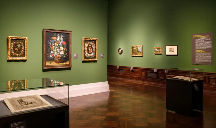 Raumansicht mit Bildern vor grüner Wand