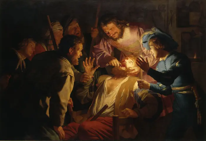 Eine Männergruppe beobachtet in einem dunklen Zimmer, wie ein Zahnarzt einen Zahn eines Mannes herauszieht. 