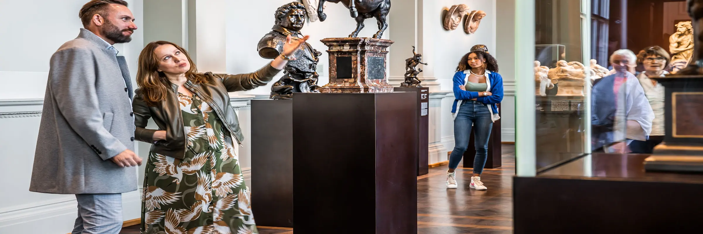 ein Mann und eine Frau schauen sich eine Skulptur in einem Museumsraum an
