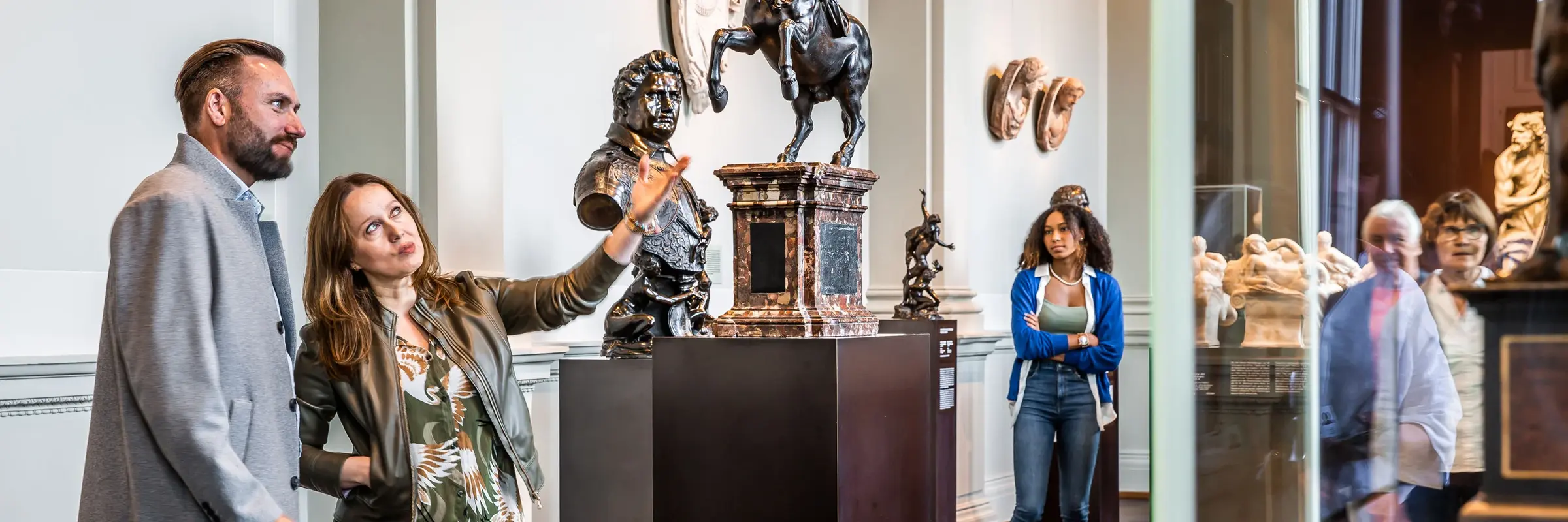ein Mann und eine Frau schauen sich eine Skulptur in einem Museumsraum an