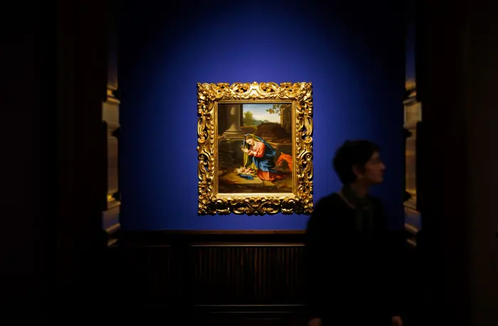 Menschen in einem Ausstellungsraum mit Gemälden an der Wand