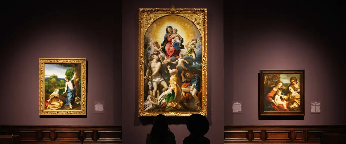 Besucher in einer Ausstellung mit großen Gemälden