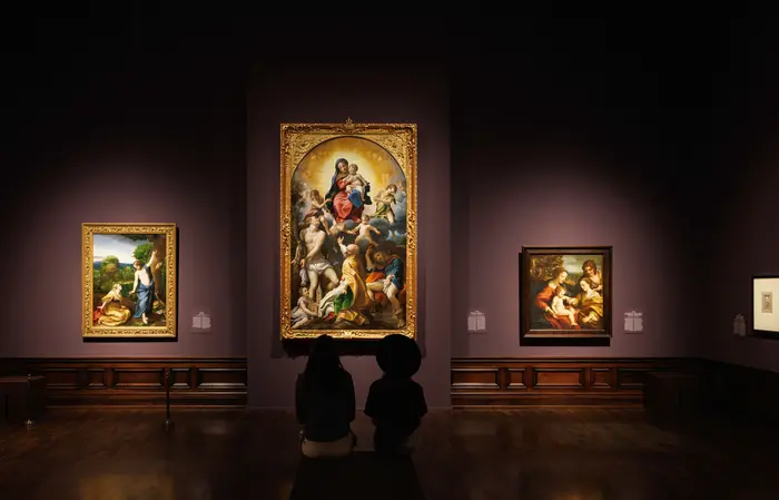 Besucher in einer Ausstellung mit großen Gemälden
