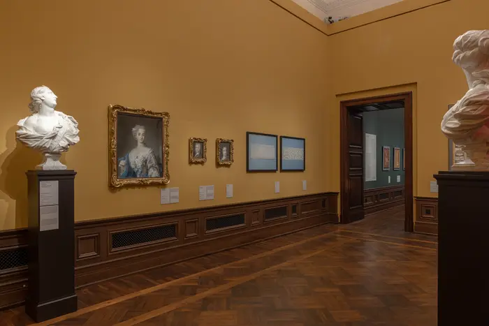 Eine Ausstellungsansicht mit Büsten und Gemälden