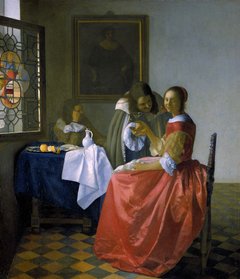 ein Mädchen in rotem Kleid hält ein zartes Weinglas in der Hand, das ihr wohl gerade von einem sich zu ihr beugenden Mann überreicht wurde