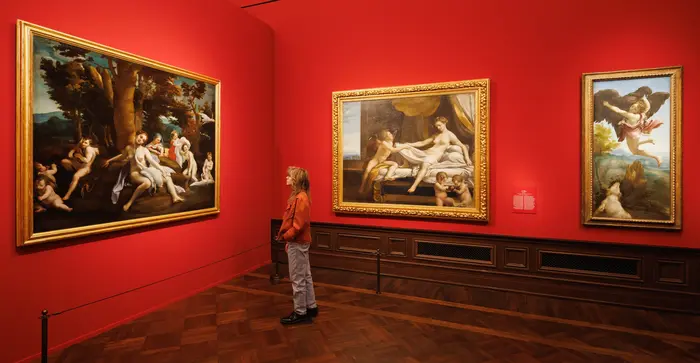 Menschen in einem Ausstellungsraum mit Gemälden an der Wand
