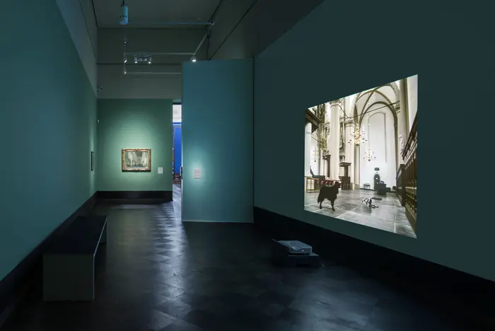 Ausstellungsansicht einer Videoarbeit des Künstlers Bojan Šarčević mit Gemälden niederländischer Kircheninterieurs im abgedunkelte Semperkabinett