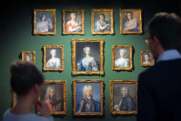 Zwei Besucher betrachten Pastellgemälde